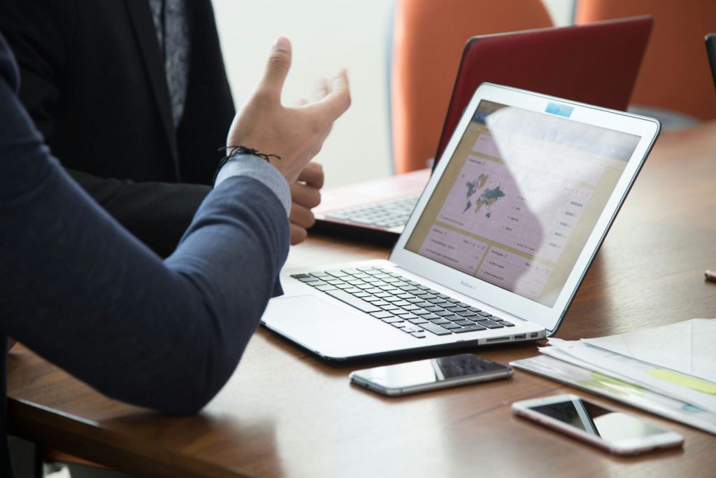 personne en chemise noire à manches longues utilisant un MacBook Pro